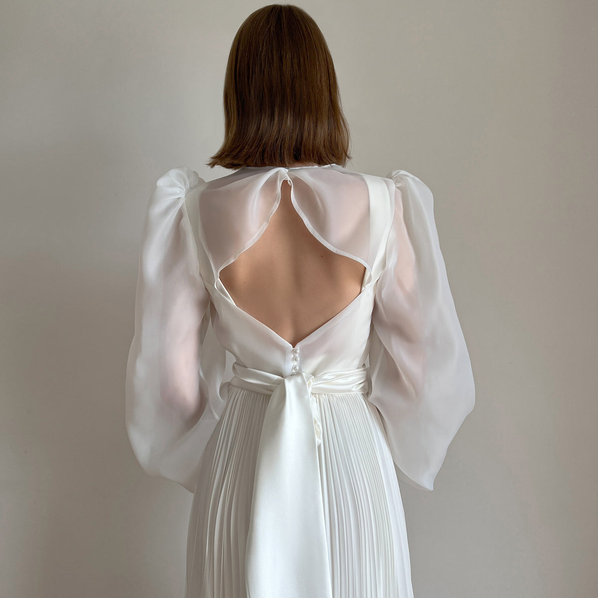 Pleated wedding dress with organza blouse, covered back detail