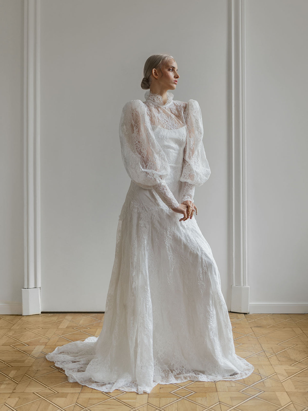 Full-length view of the high-neck lace wedding dress showing its fitted mermaid silhouette.
