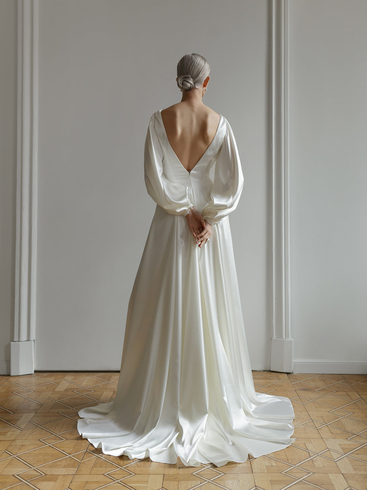 Full-length view of the satin wedding dress showing the long silk train.