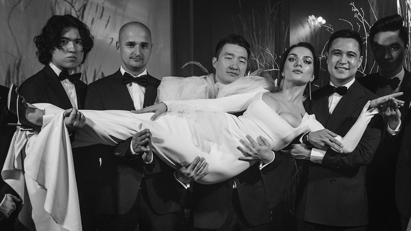 bride in the arms of the groom and four friends