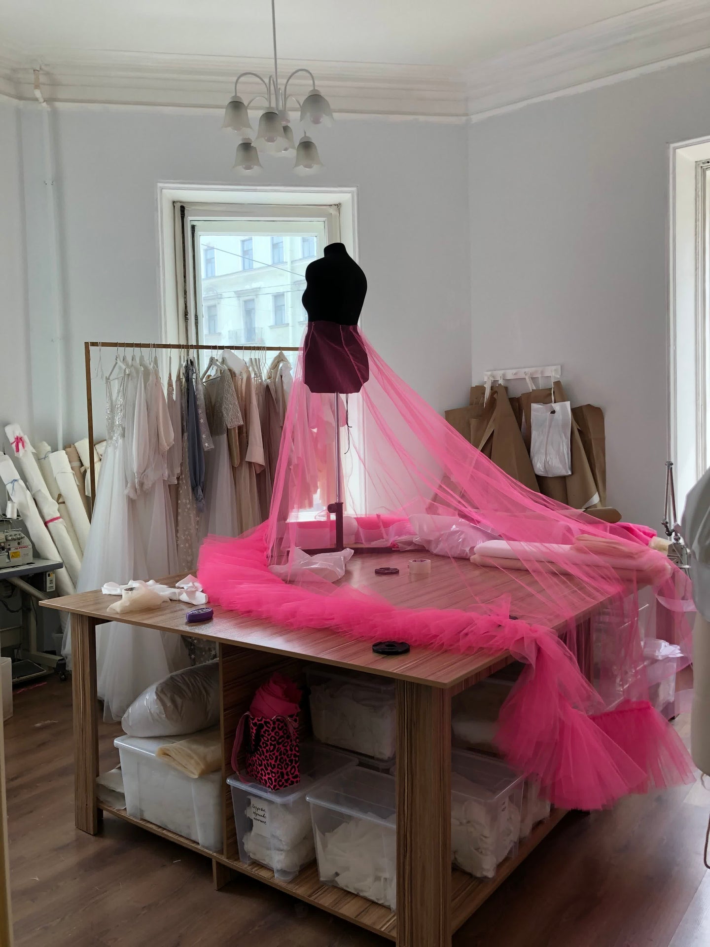 Bridal atelier production workspace in Ansignan, France, with pink tulle on the cutting table