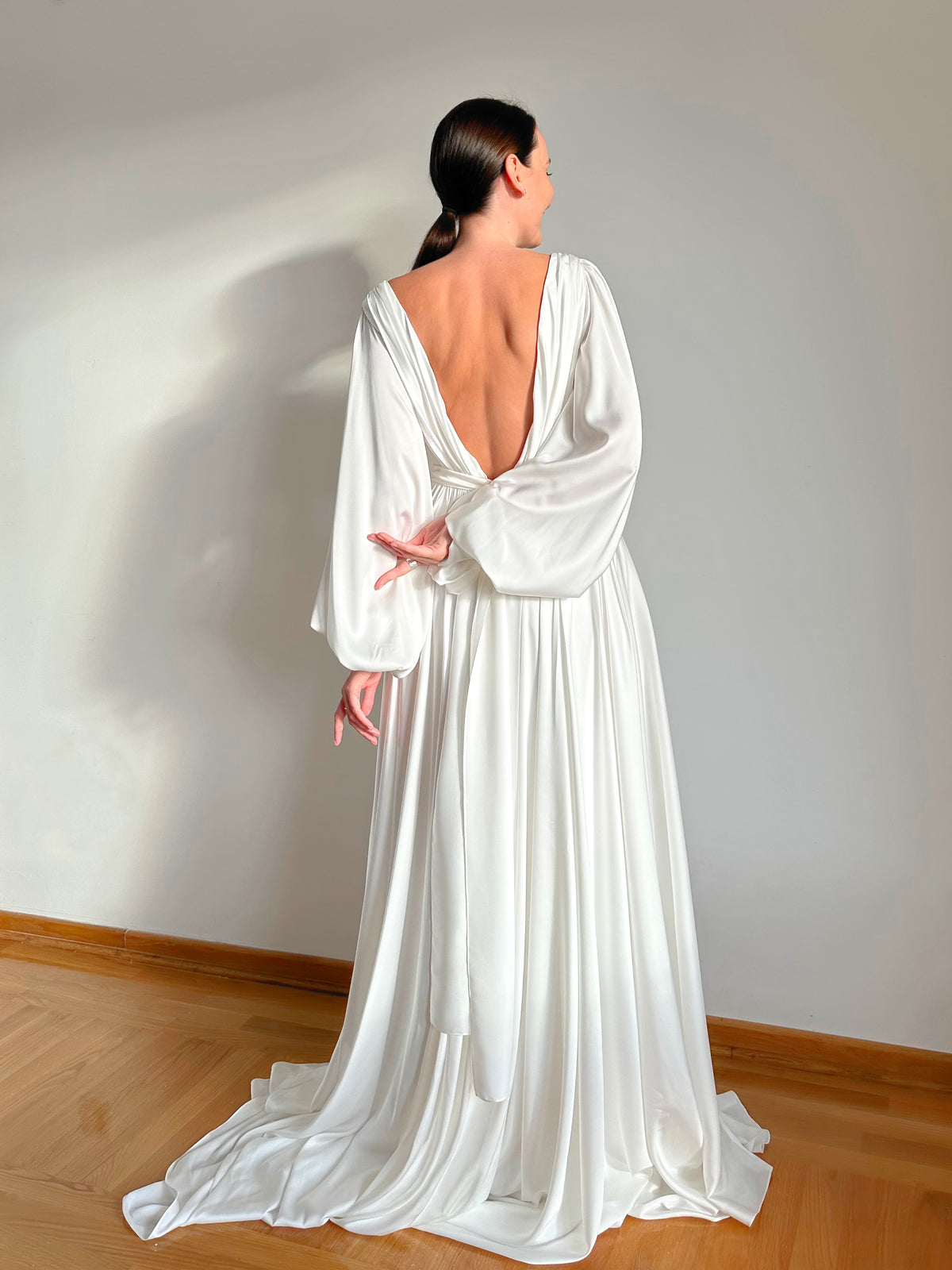 Open V-back with balloon sleeve detail on an artificial silk wedding dress
