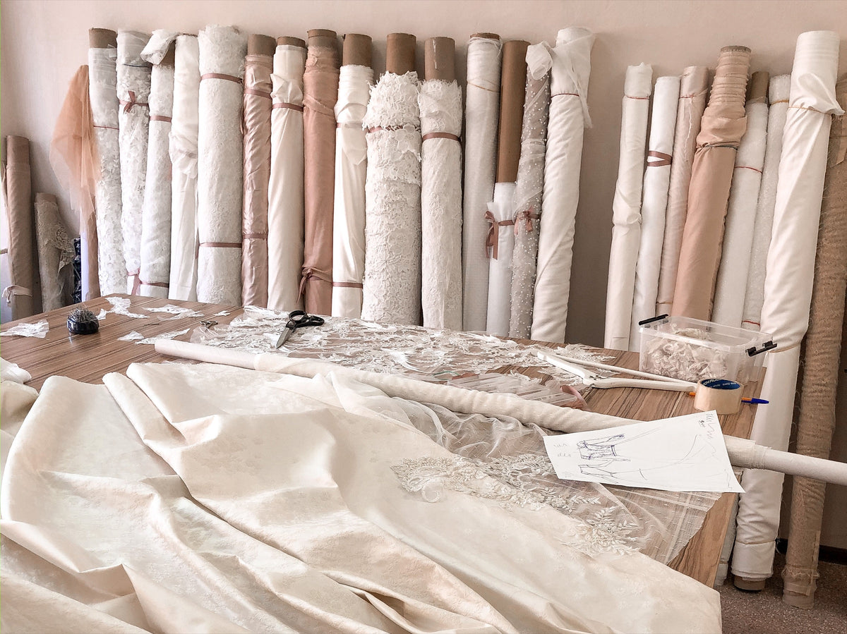 Fabric rolls and lace on the worktable inside the Lutien Bridal atelier in Ansignan