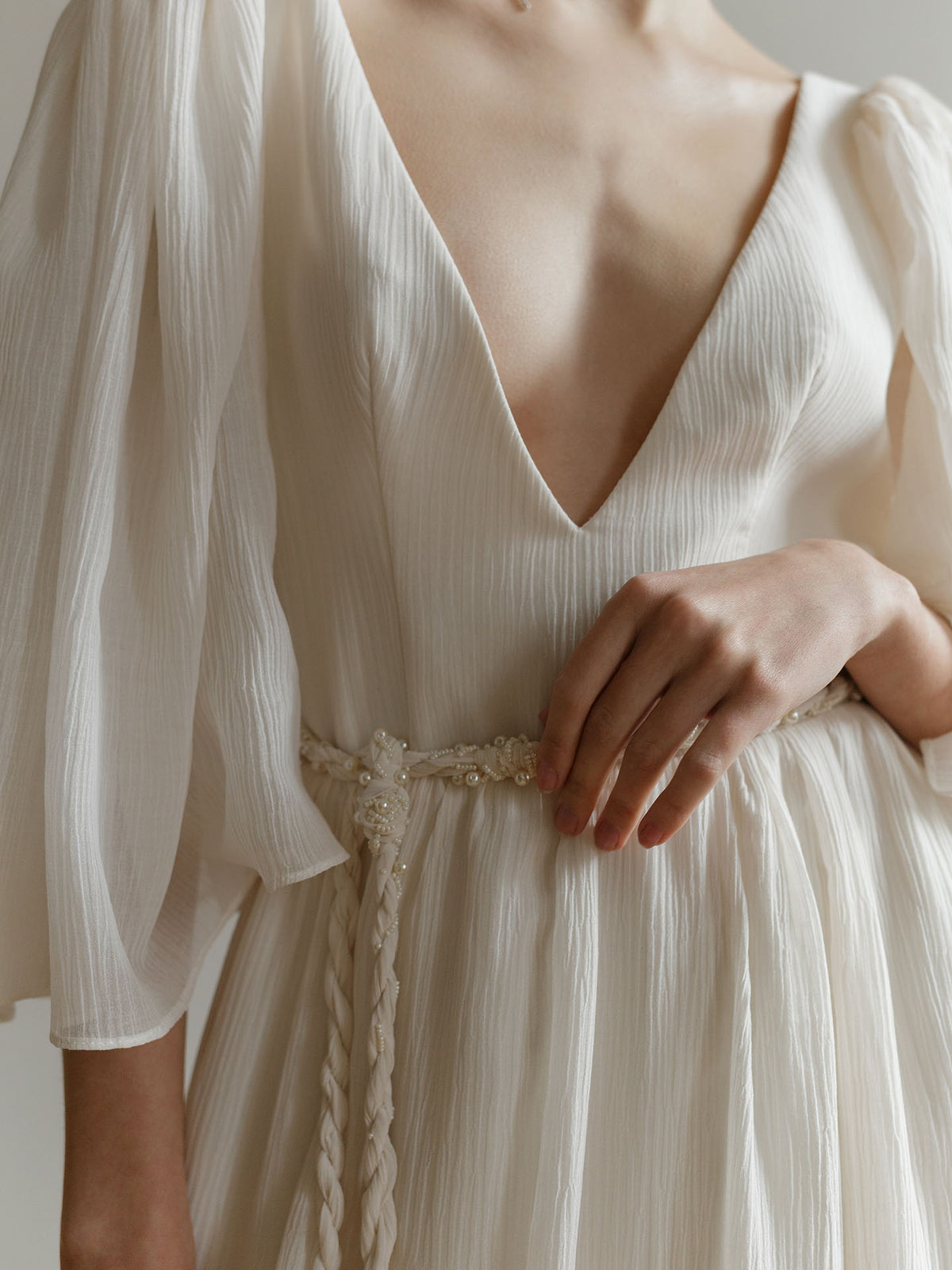 Detail of the deep V-neckline on the ivory crash-chiffon wedding dress bodice.