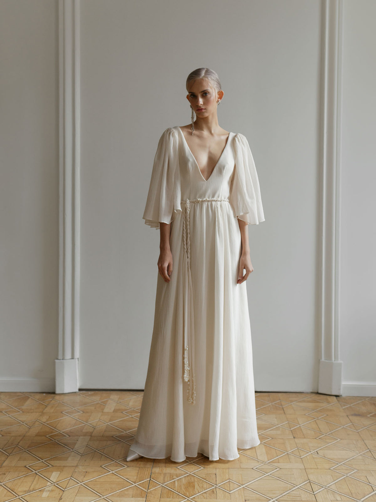 Lutien Bridal custom wedding dress in ivory crash-chiffon with a fitted bodice and flowing skirt.