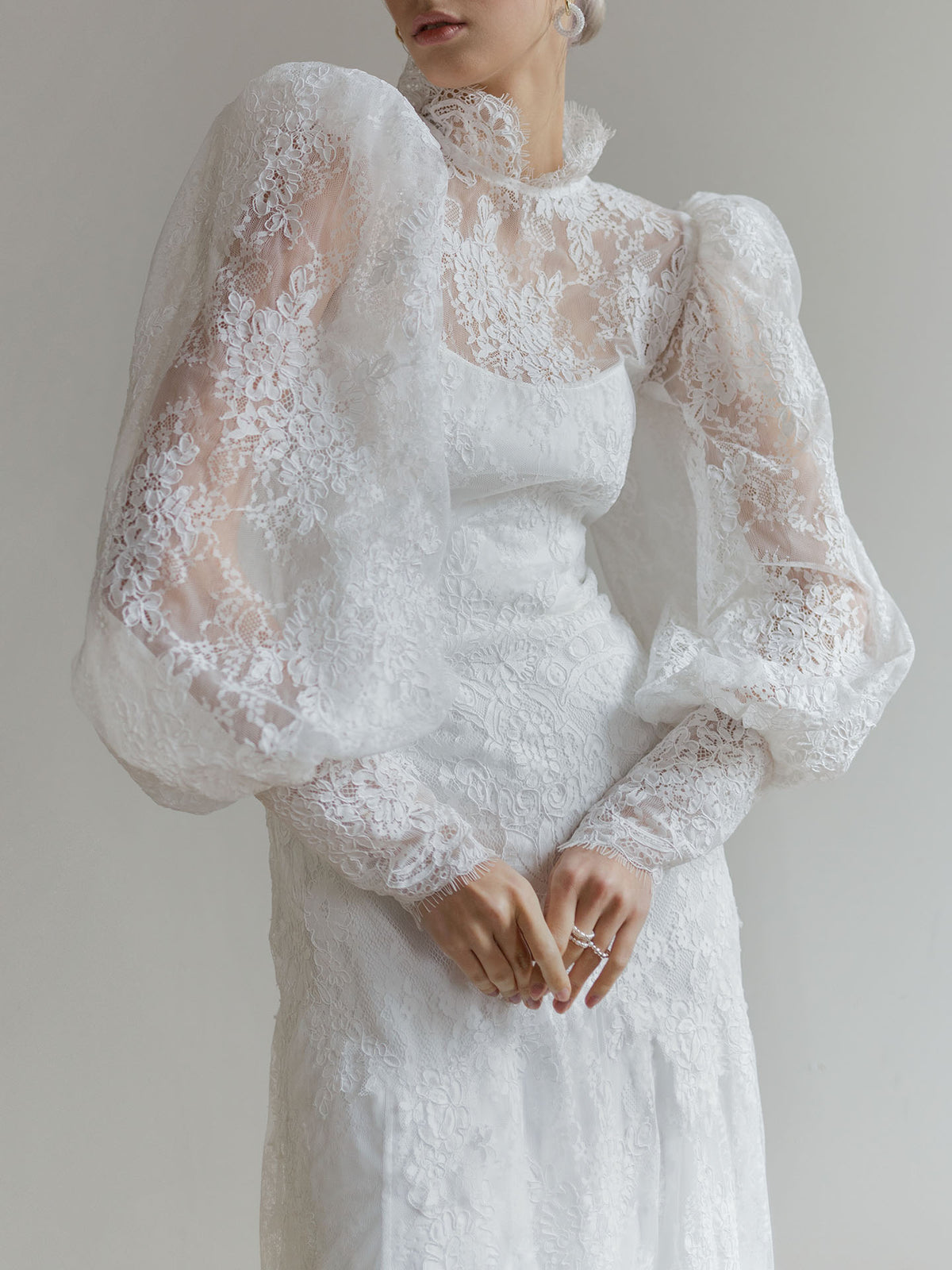 Detail of the Victorian-style lace sleeves and high collar on the wedding dress.