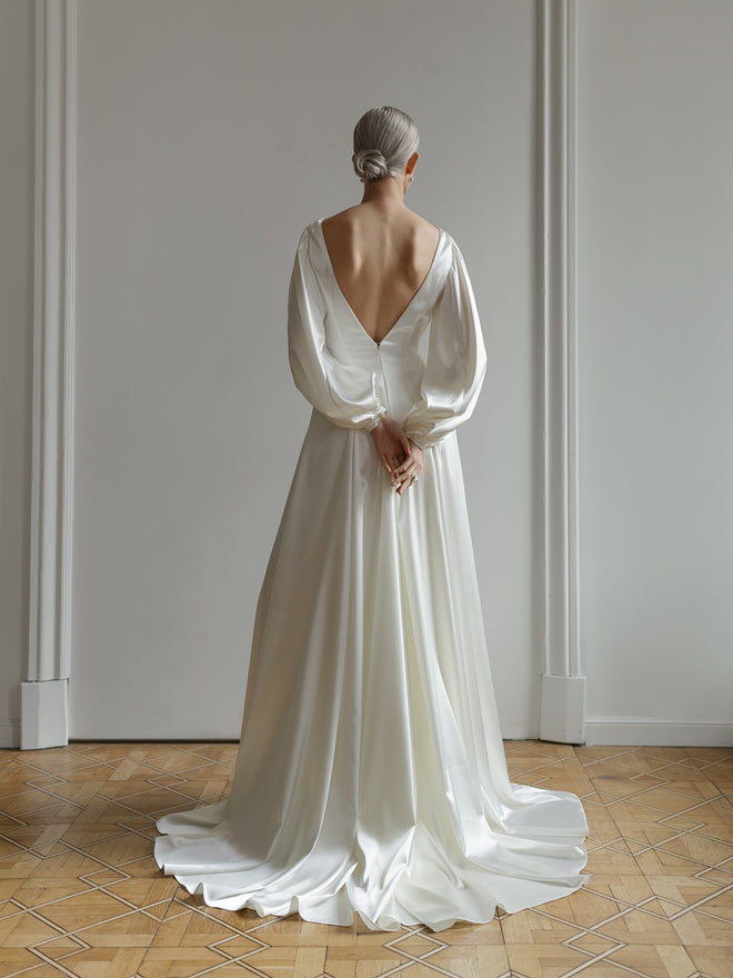 Full-length view of the satin wedding dress showing the long silk train.