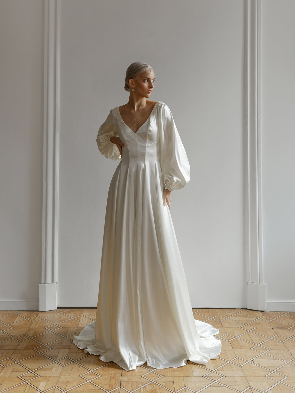 Close-up of the long sleeve and cuff detail on the satin open-back wedding dress.